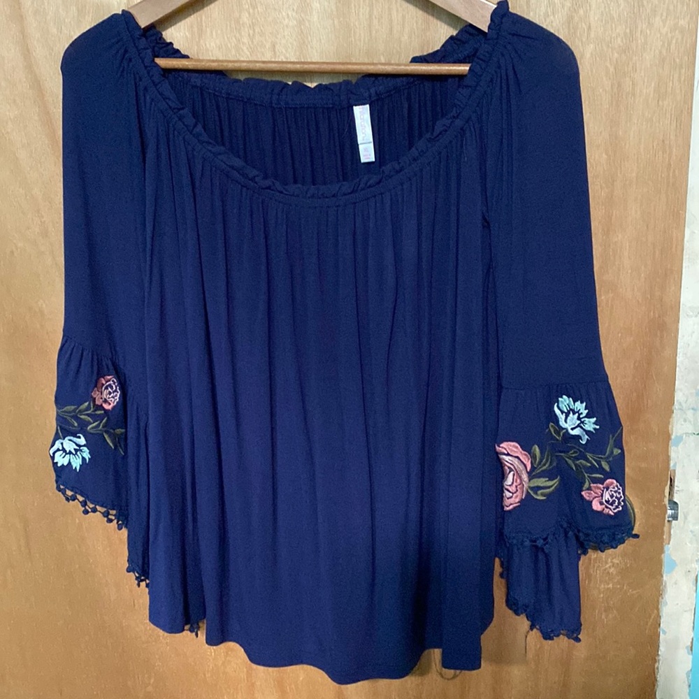 Off the shoulder top with embroidery on sleeves are flared the size is an XL .